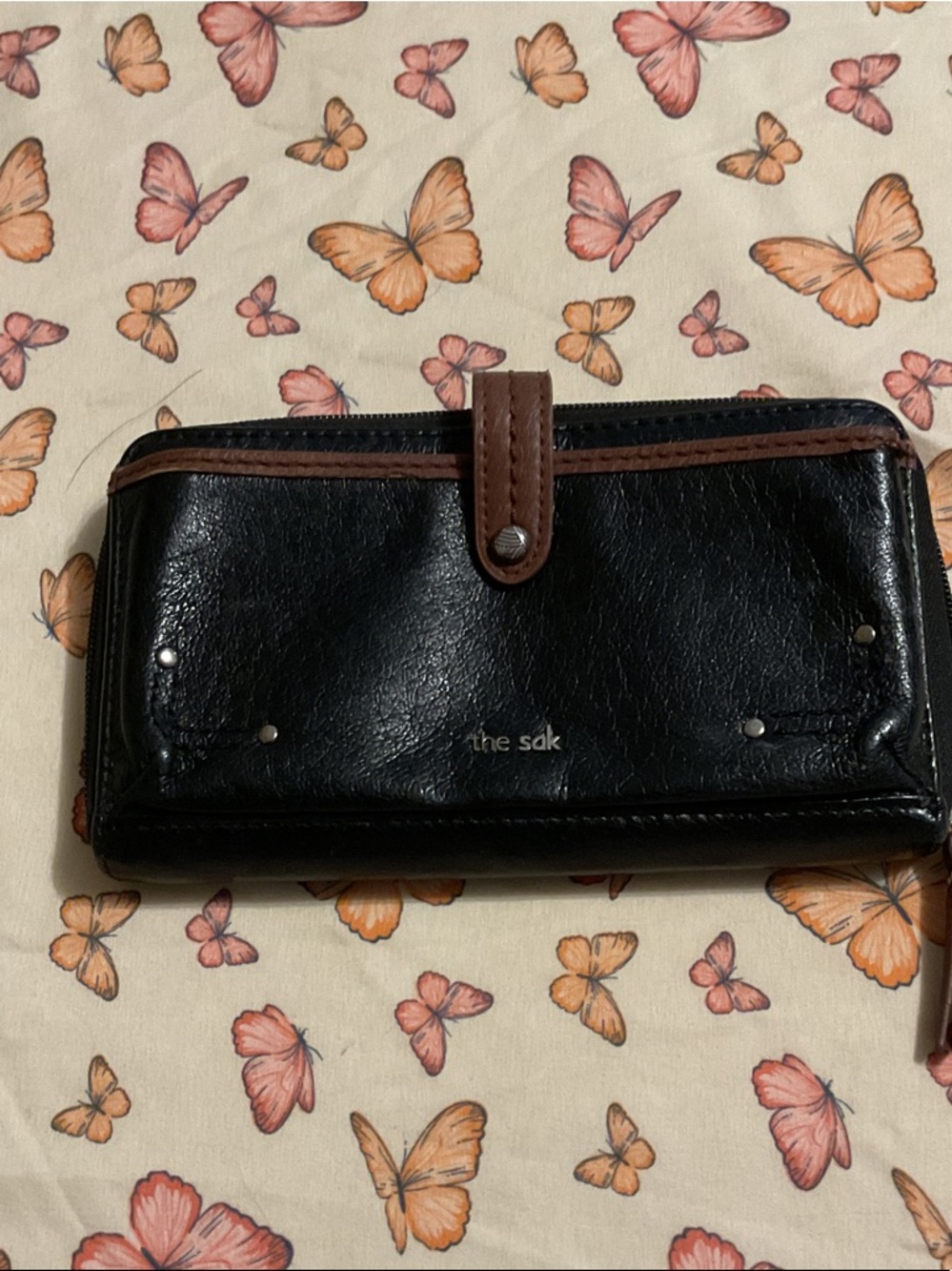 The Sak Black Leather Wallet with Brown Trim and Snap Tab